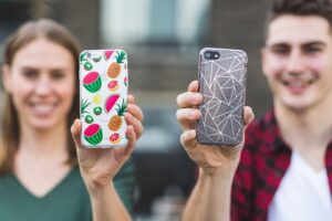 engineering resins used in mobile phone cases. Picture shows two people holding their phone with cases up.